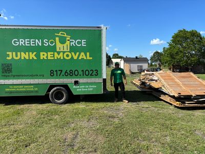 Green Source Junk Removal employee getting ready to load wood onto truck. 