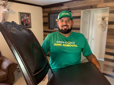 Green Source Junk Removal employee holding a chair 
