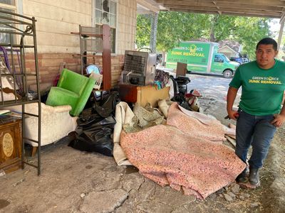 Green Source Junk Removal employee standing next to trash 