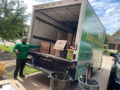 Green Source Junk Removal employee removing cardboard from a garage