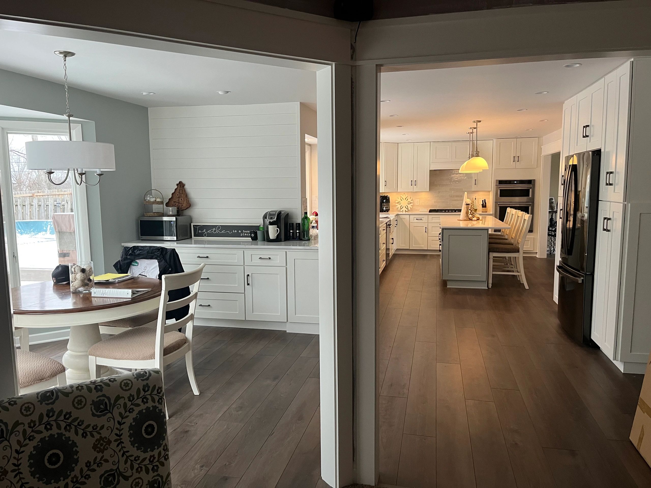 Modern kitchen and dining area with white cabinetry and pendant lighting.