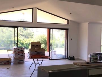 Unfinished interior with large windows and boxes.