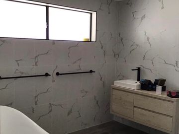 Stylish bathroom with marble walls and modern fixtures.