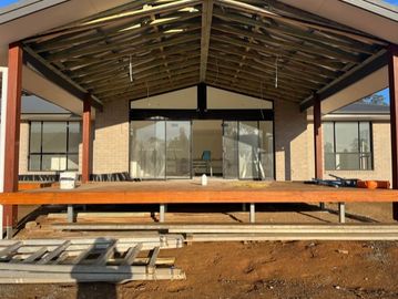 A house under construction with exposed roof beams.