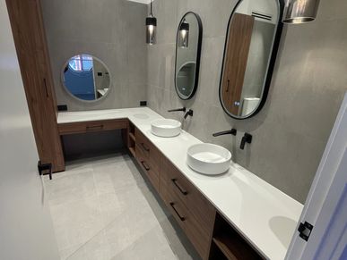 Modern bathroom with dual sinks, round mirrors, and pendant lights.