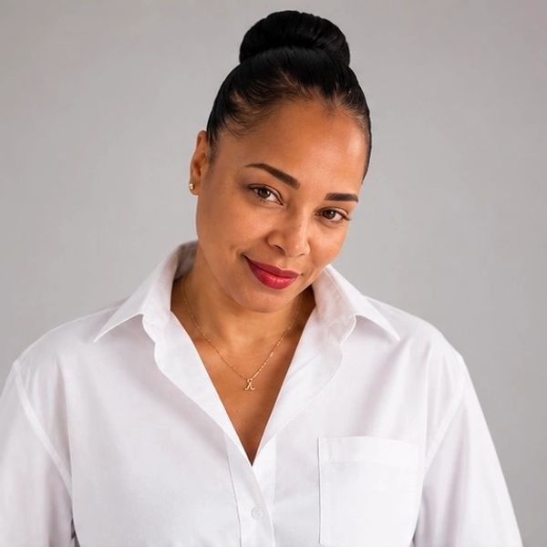 Confident woman smiling, wearing a white shirt.