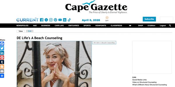 A woman with blonde hair smiles thoughtfully, framed by a wrought iron fence.