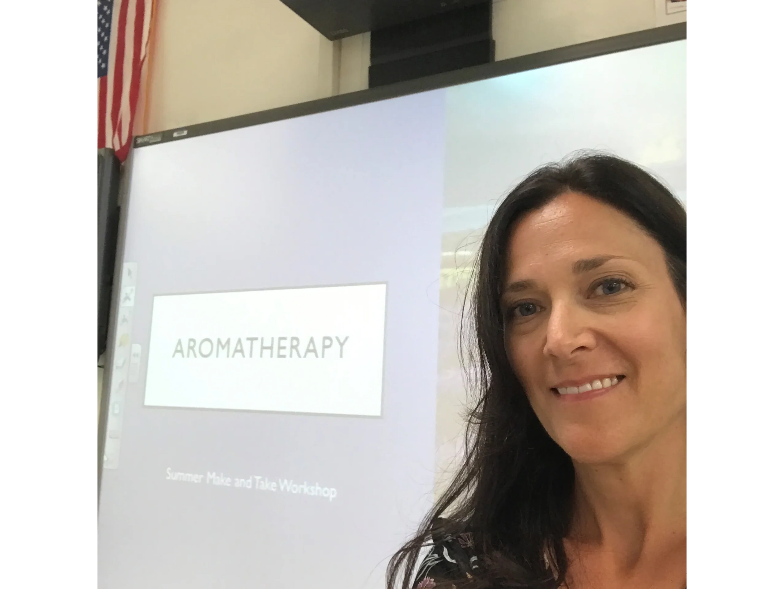 Woman in front of presentation teaching Aromatherapy. 