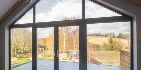 Large glass doors and windows framing a scenic rural landscape.