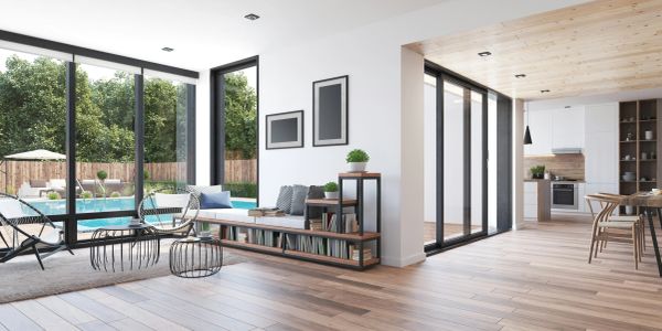 Modern living room with large windows overlooking a pool and garden.