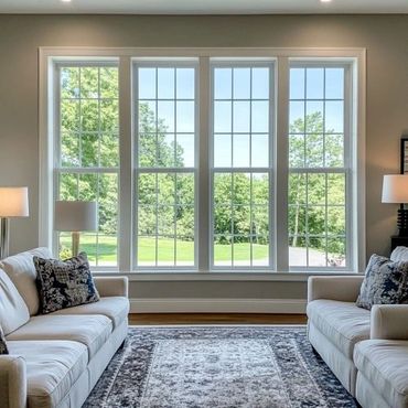 Bright living room with large windows and two sofas facing each other.