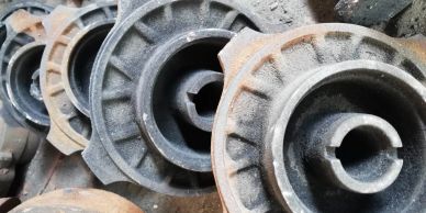Stacked, rusty metal machine parts in a workshop or storage area.