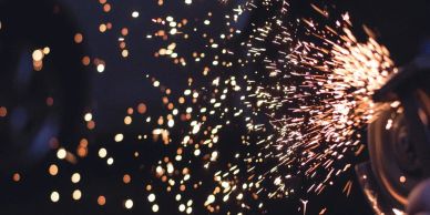 Bright sparks flying from a metal grinding tool in action.