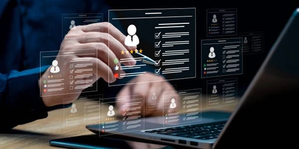 Hand interacts with virtual profiles on a laptop screen for digital management.