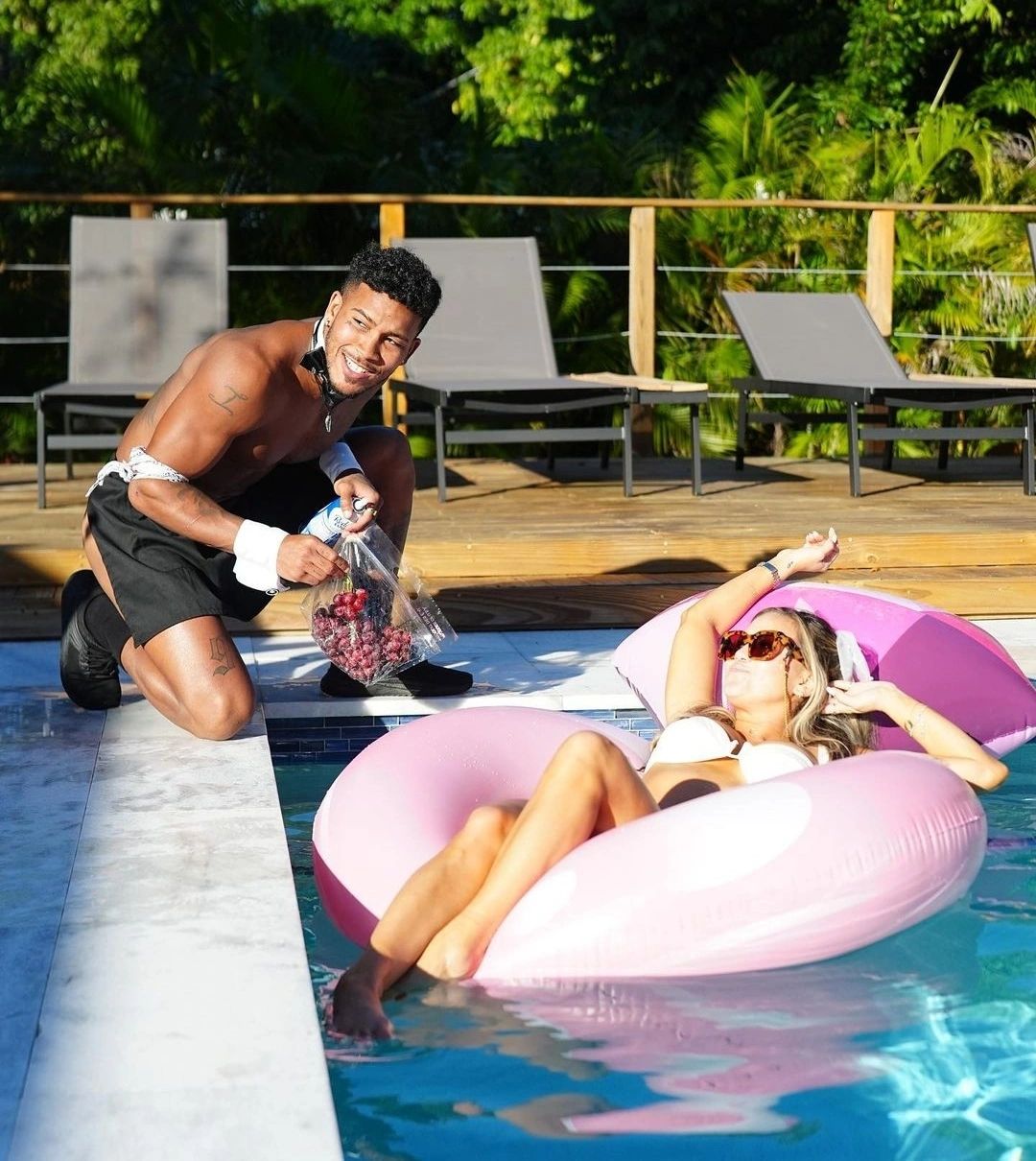 cabana boy in Miami pampers and hand feeds grapes to a soon to be bride poolside during party. 