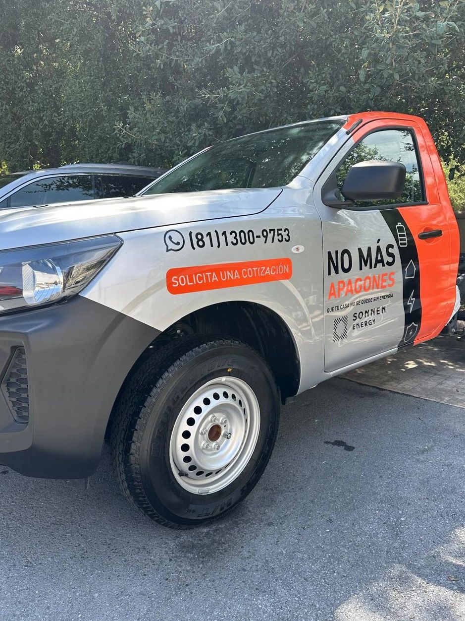 Camioneta promocional de energía solar con texto en español.
