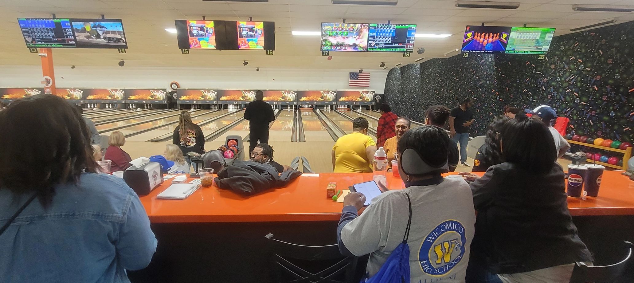 A lively bowling alley with people enjoying games and socializing.