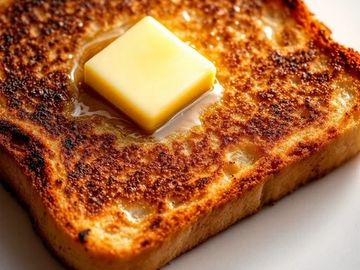Buttered toast with a melting pat of butter on top.