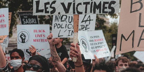Protesters holding signs demanding justice and supporting Black Lives Matter.