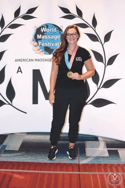 Woman with medal at World Massage Festival.