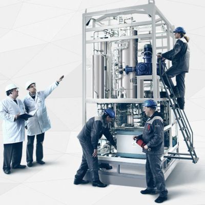 Engineers inspecting and operating industrial machinery in a lab setting.
