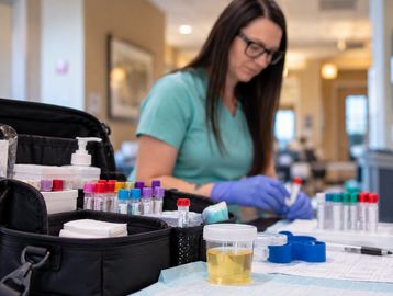 Medical professional handling test tubes in a lab.