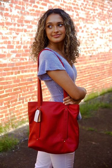A person carrying a red leather bag
