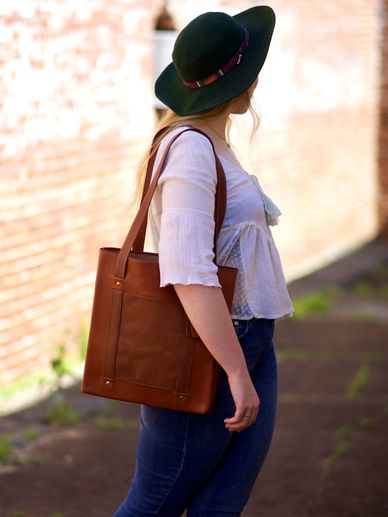A person carrying a brown leather bag