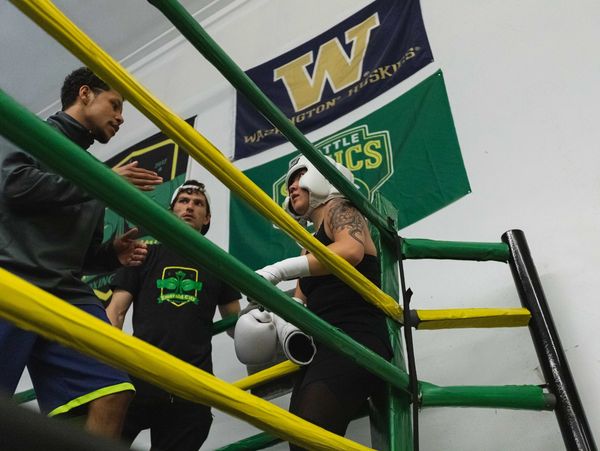 boxing coach working with boxer in corner of boxing ring between rounds