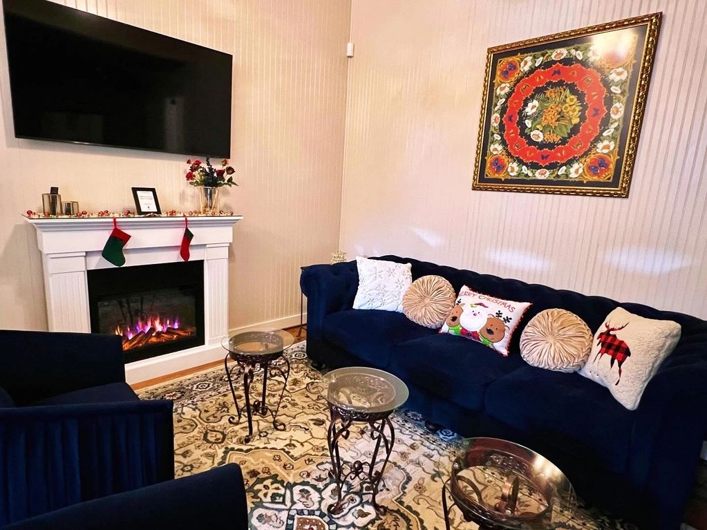 Formal living room with fire place and couch with Christmas pillows