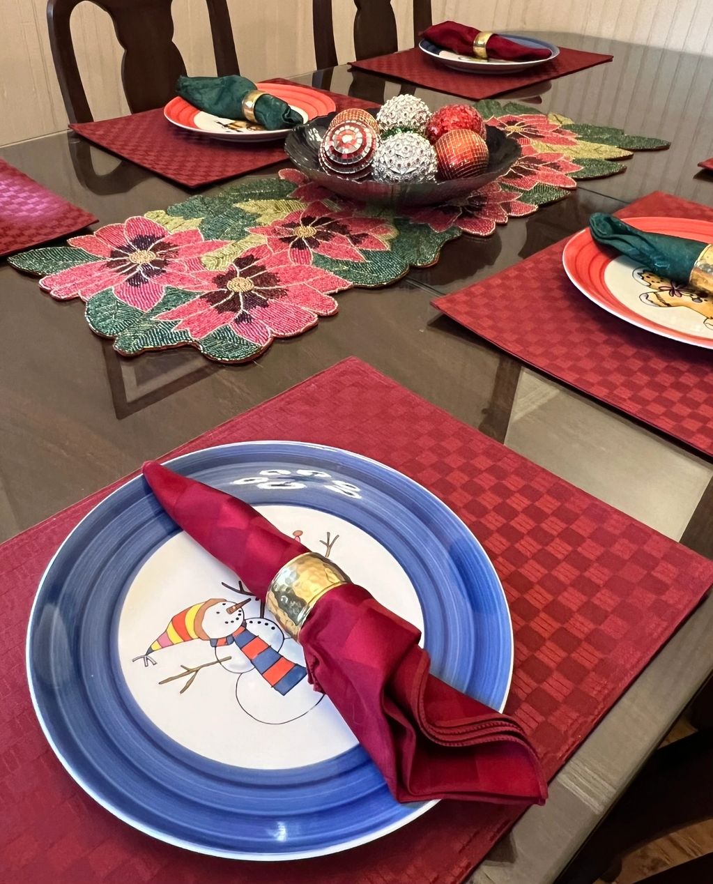 Dining room table with Christmas plates, placemats, and napkins