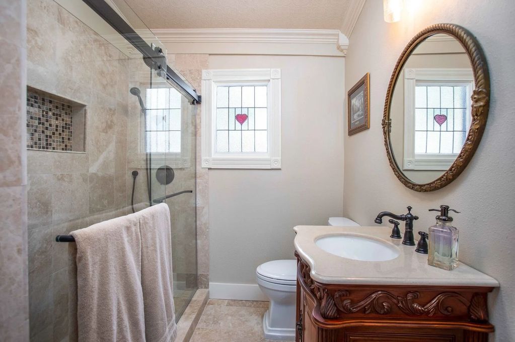 Bathroom renovated with polished marble, a walk-in shower, rain head shower and handheld shower wand