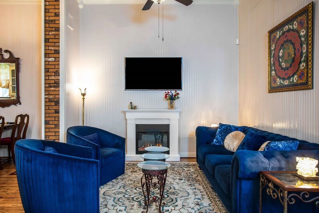 Living room with electric fireplace and art deco chairs. A smart TV with several complementary apps.