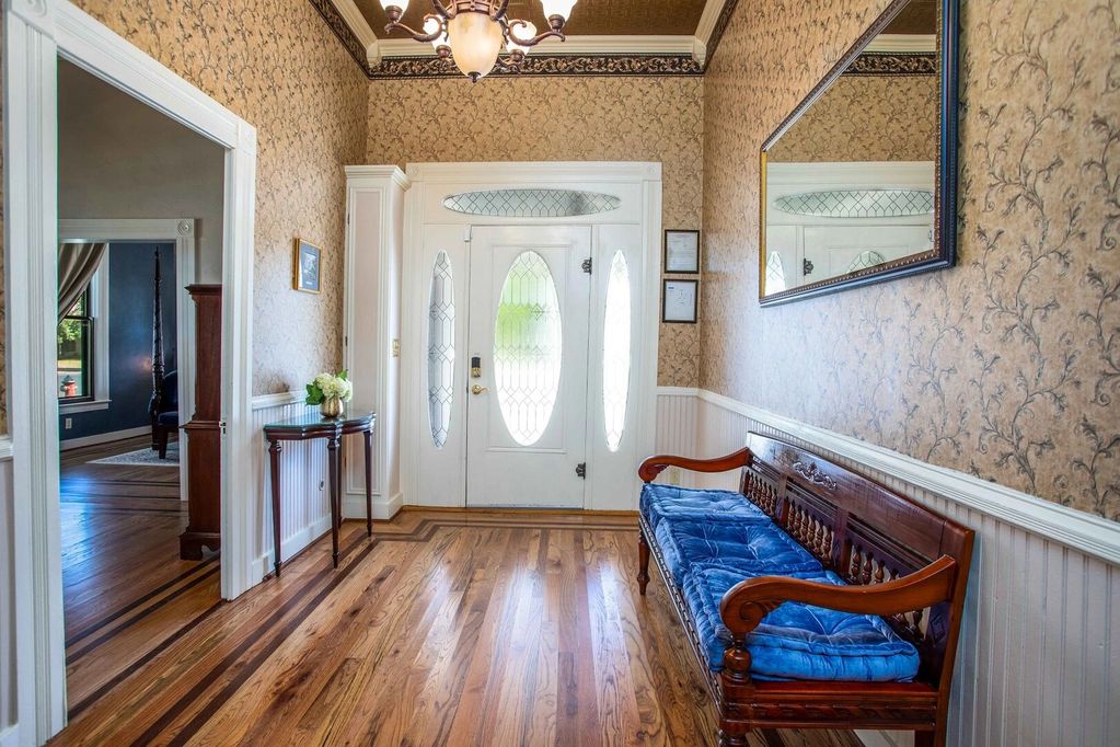 Antique chandelier and hardwood floors in the grand foyer with 12 foot ceilings with crown molding.