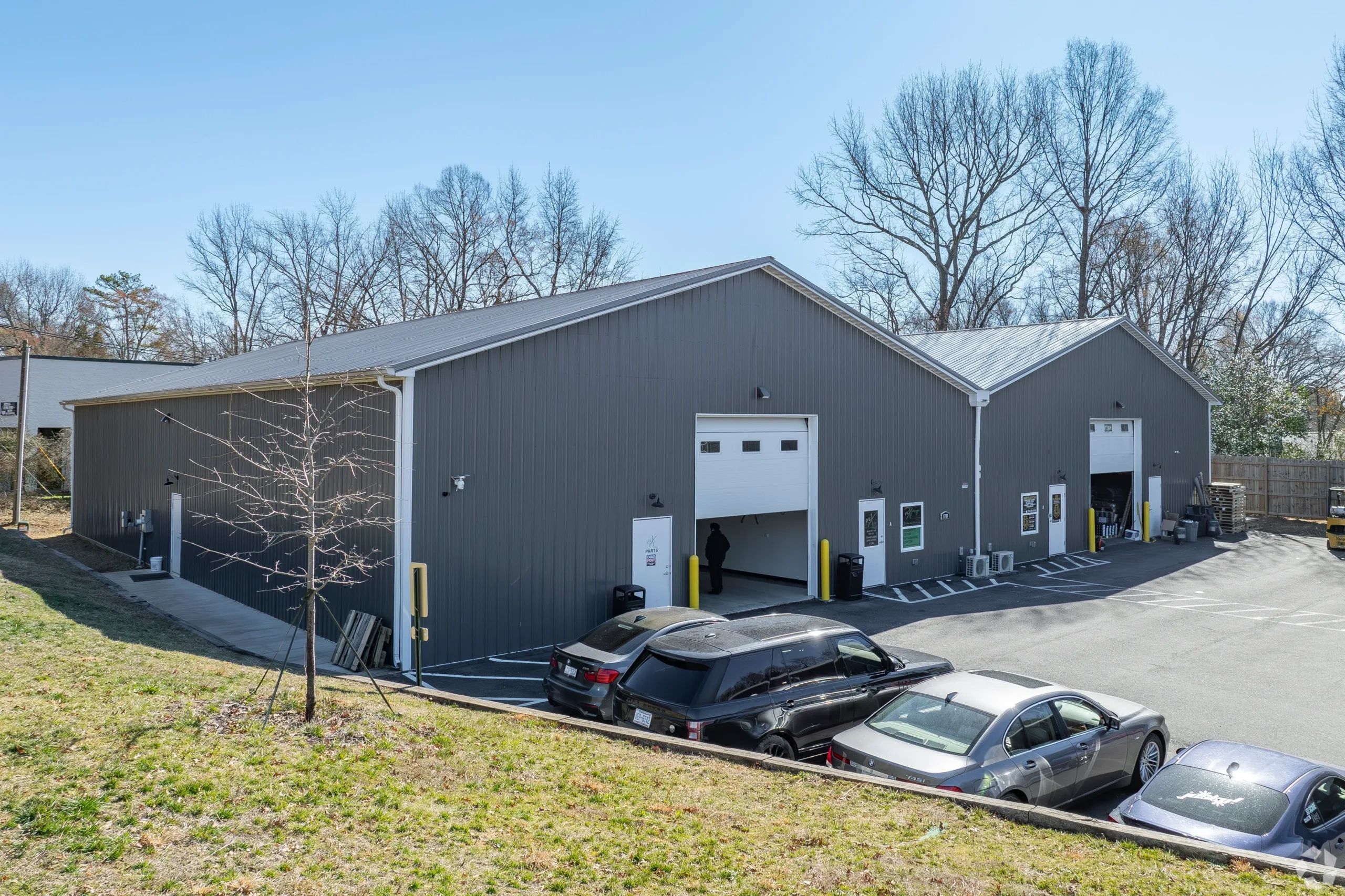 Industrial building with parking spaces and parked cars.