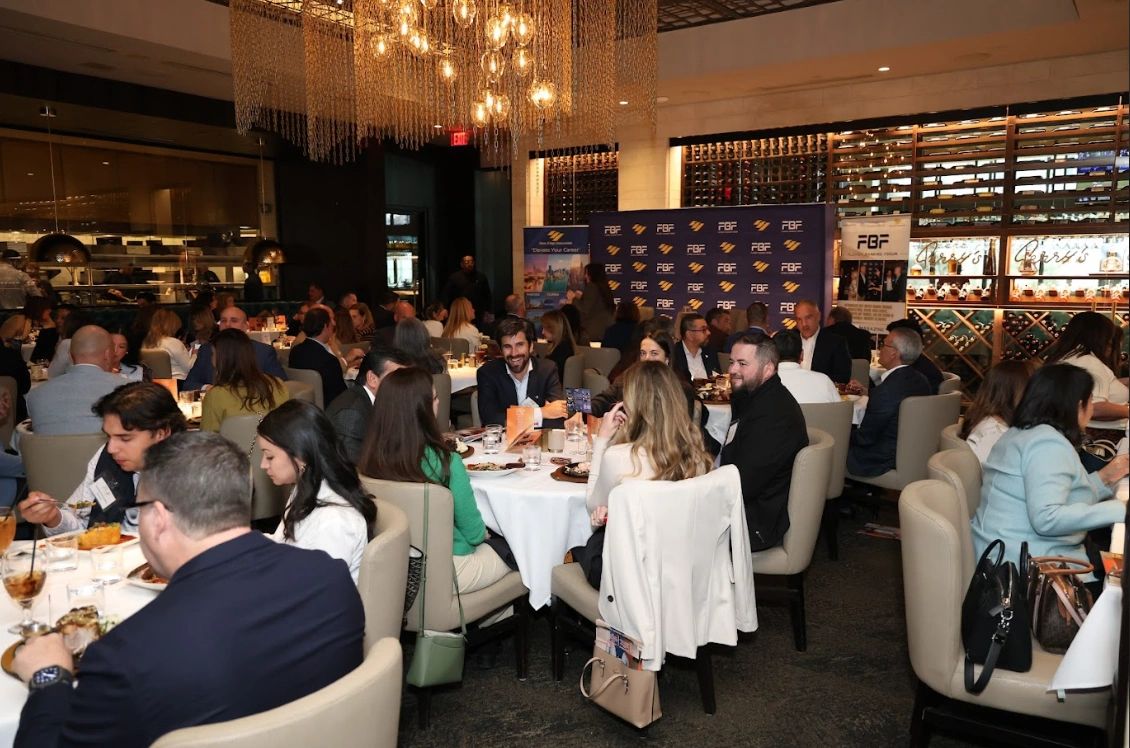 People dining and socializing at a formal event in a restaurant.