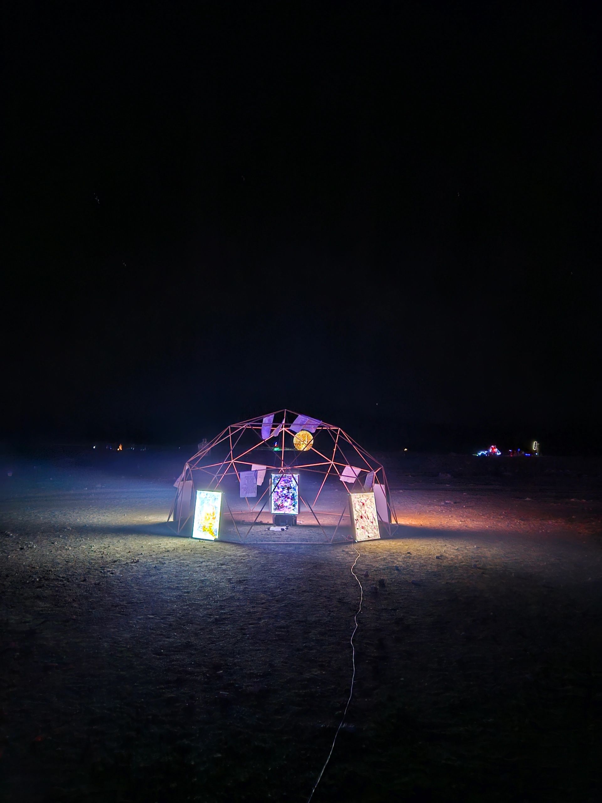 Light installation under a night sky.