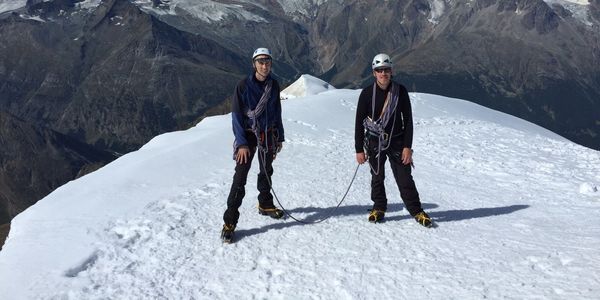2 men on a mountaintop during winter
