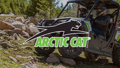 An Arctic Cat off-road vehicle driving on rocky terrain.