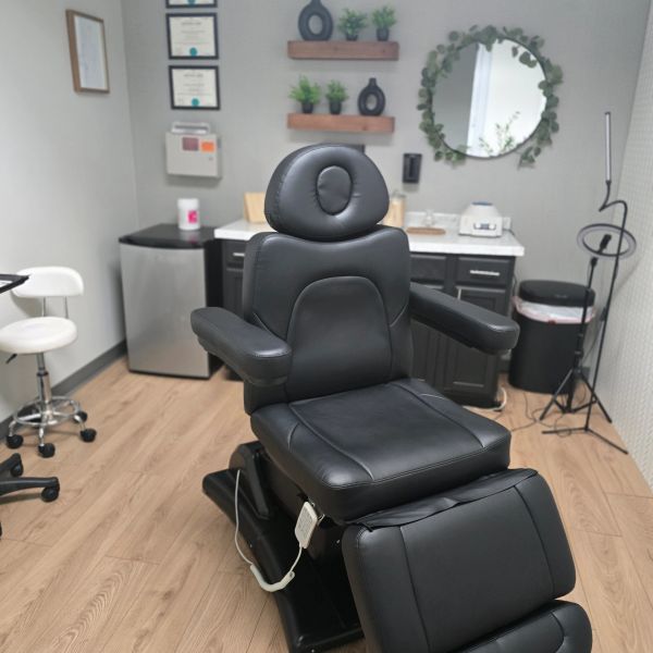 Black leather medical or dental chair in a clean, modern office.