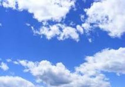 Bright blue sky with scattered white clouds on a sunny day.