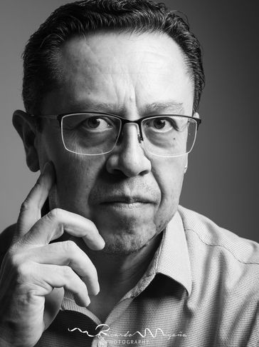 Retrato en blanco y negro de un hombre con gafas pensativo.