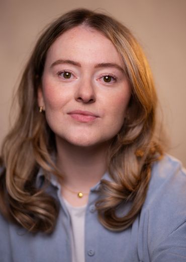 Portrait of a young woman with light brown hair and a calm expression.