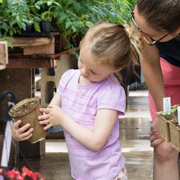 mom and child shopping for plants in cowpots