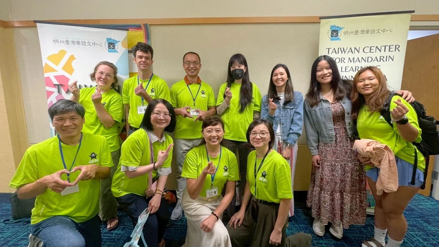 Staff and teachers with heart hand gestures at Taiwan Center for Mandarin Learning.
