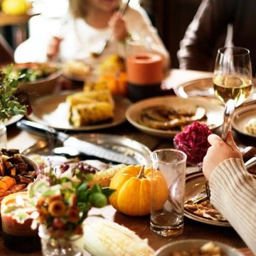 A festive meal with pumpkin and wine on a wooden table.