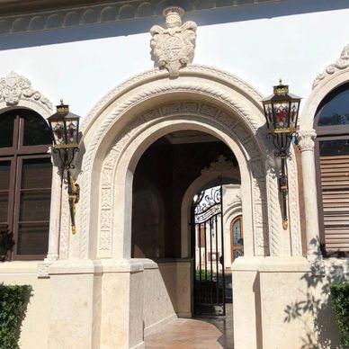 Elegant stone archway with decorative lamps.