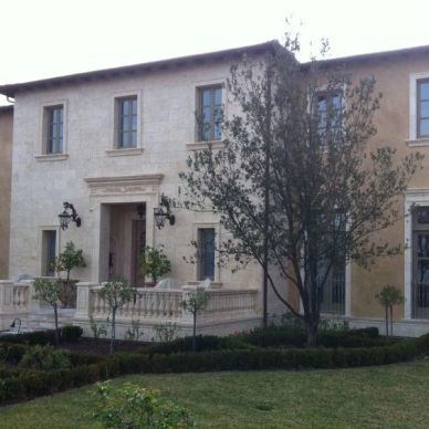 Large two-story house with stone facade and front yard.
