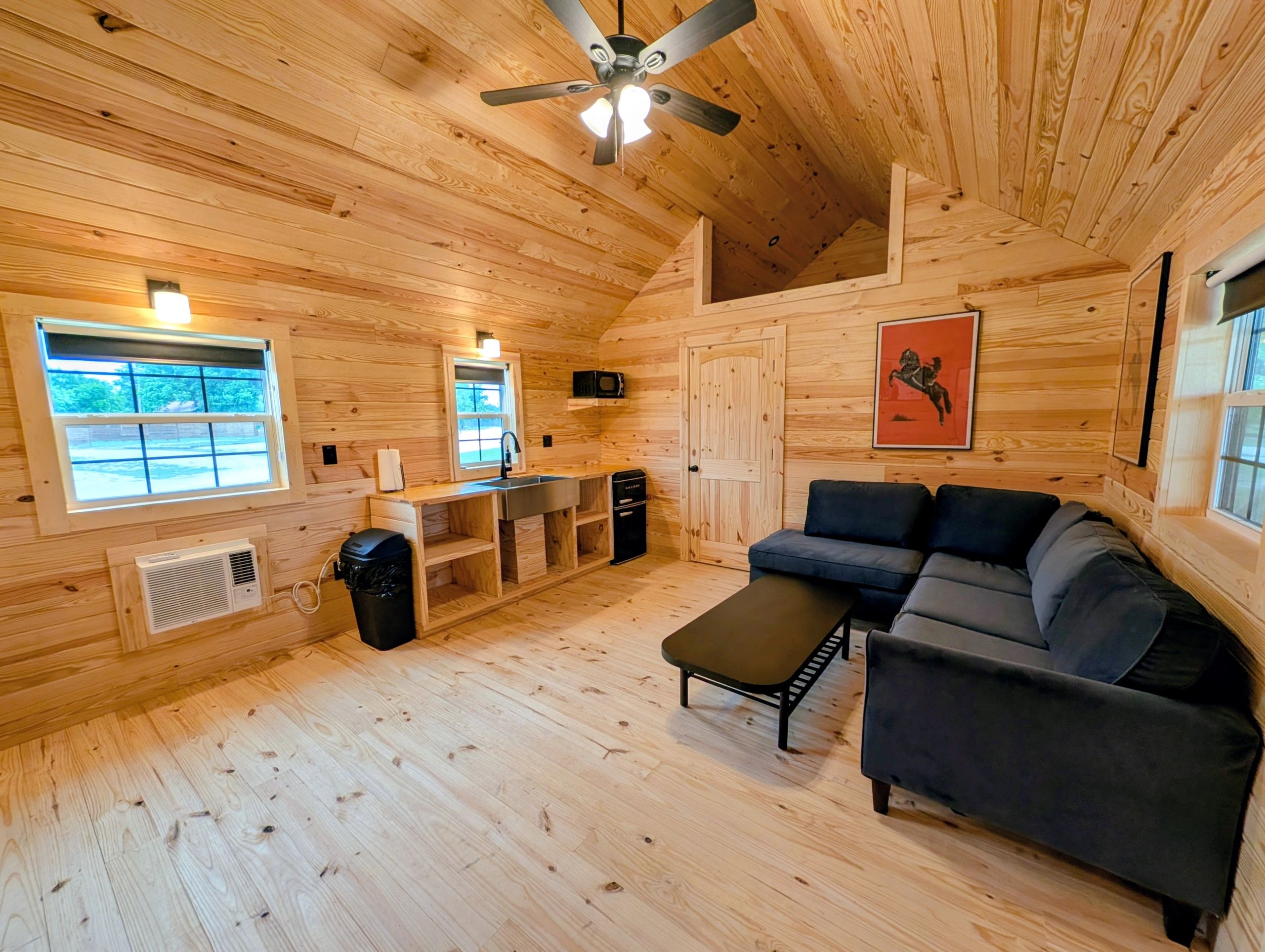 Cozy wooden cabin interior with modern amenities and a comfortable sofa.
