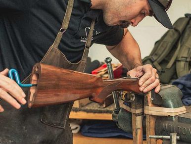 Man repairing or assembling a wooden rifle stock.